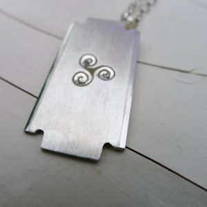 Sharpness: The razor shape symbolises sharpness, precision, or focus, reflecting the wearer's determination and focus in life. Life cycle: The triple spiral symbolizes the cycle of birth, death, and rebirth. It represents the journey of the soul