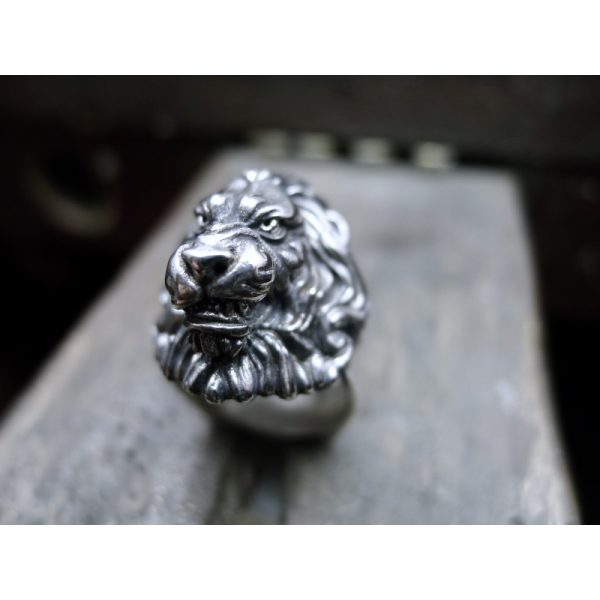 Crafted from high-quality silver, this ring features a snarling lion with a flowing mane, intricately carved. The recesses of the design have been oxidised to a rich black color, bringing out the detail of the lion's features and adding depth to the overa Crafted from high-quality silver, this ring features a snarling lion with a flowing mane, intricately carved. The recesses of the design have been oxidised to a rich black color, bringing out the detail of the lion's features and adding depth to the overa