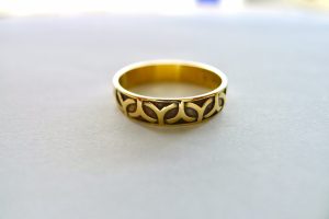 This stunning gold Celtic band ring is a stunning piece of irish jewelry with a reccesed Celtic leaf pattern that runs along the outside of the band.