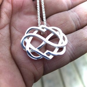 Handcrafted in Kenmare, Ireland. Celtic jewelry in the form of two hearts intwined and held together by the symbol of infinity. Irish jewelry made by Aidi Mac Dáibhí