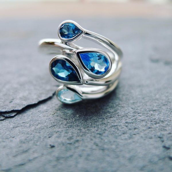 Blue Topaz ring. Closeup of pear shapes gemstones bezel set in silver Blue Topaz ring. Closeup of pear shapes gemstones bezel set in silver
