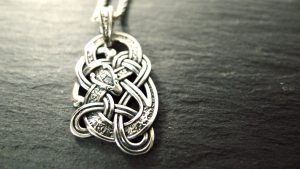 Close up of a Celtic silver pendant in the shape of an Irish Dragon